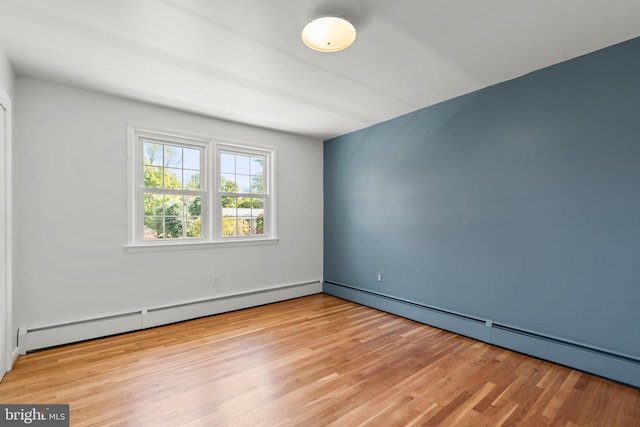 spare room with a baseboard radiator and light wood-type flooring