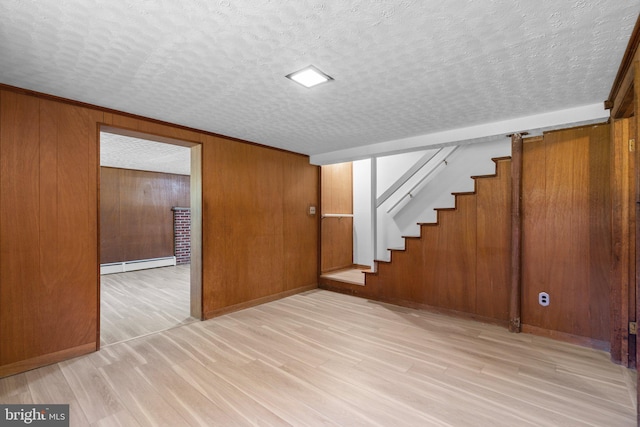 interior space featuring a baseboard heating unit, a textured ceiling, and light wood-type flooring