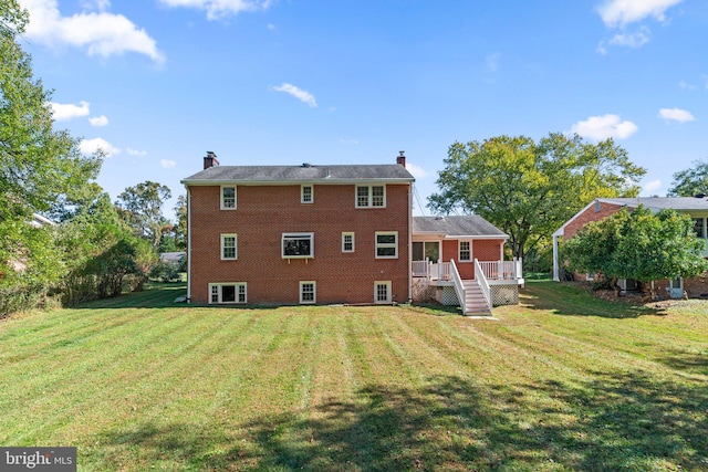 back of property with a wooden deck and a yard