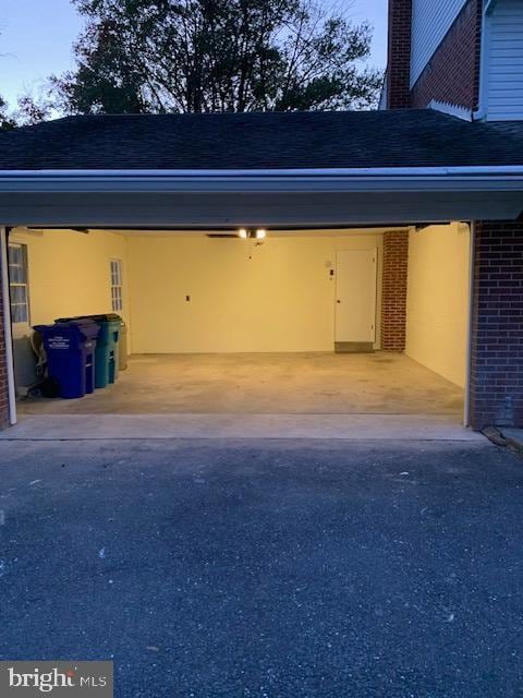 garage at dusk featuring a carport