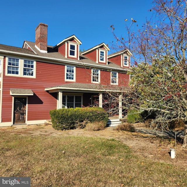 rear view of property with a lawn