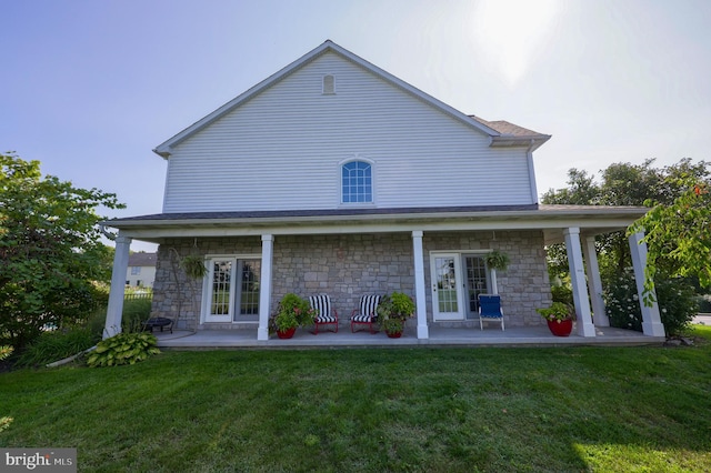 back of house featuring french doors and a lawn