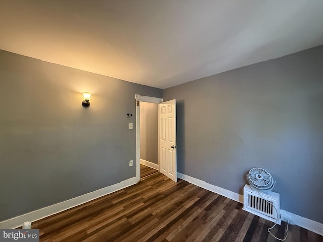 unfurnished room with dark wood-type flooring