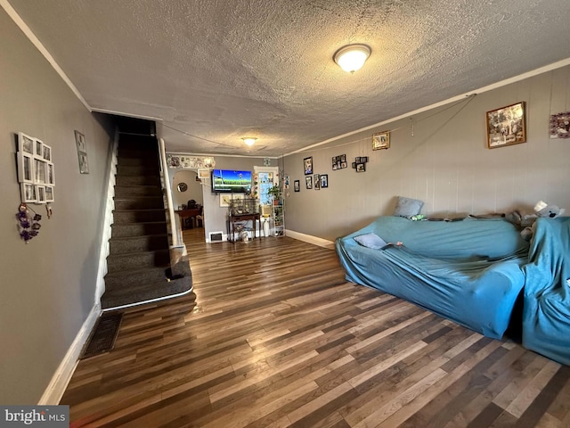 living room featuring hardwood / wood-style flooring, a textured ceiling, and crown molding