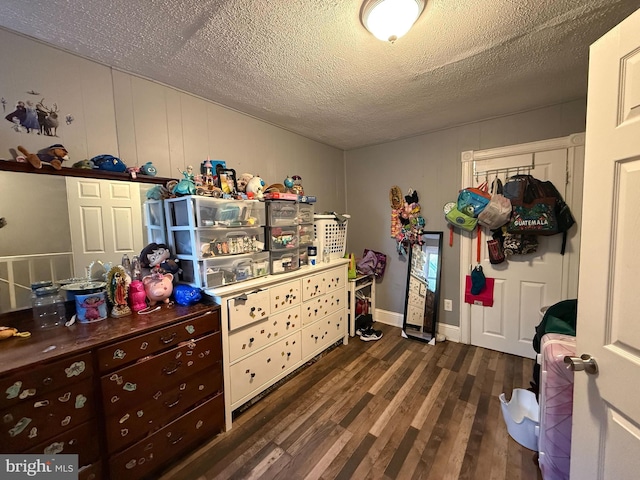 bedroom with a textured ceiling and dark hardwood / wood-style floors