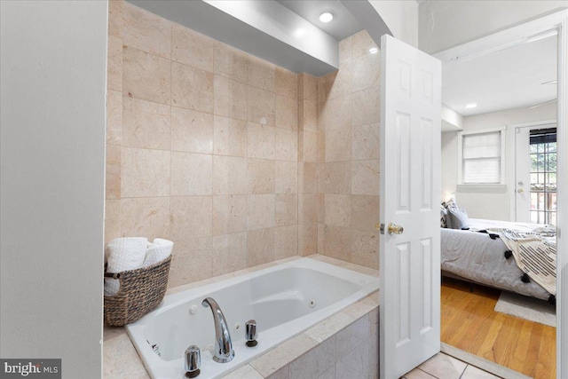 bathroom featuring tiled bath and wood-type flooring