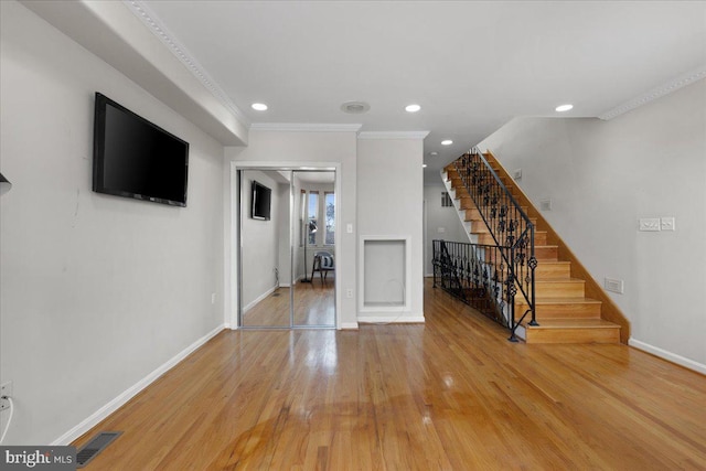 unfurnished living room featuring crown molding and wood-type flooring