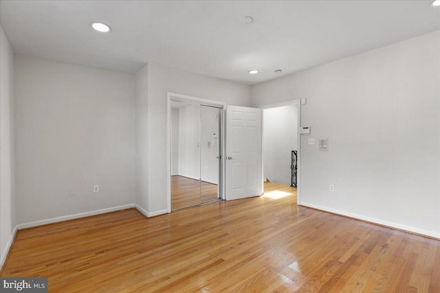 unfurnished bedroom with light hardwood / wood-style flooring and a closet