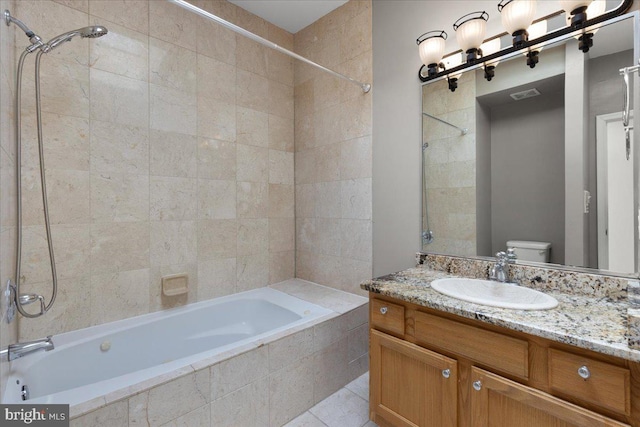 full bathroom featuring vanity, toilet, tiled shower / bath combo, and tile patterned flooring