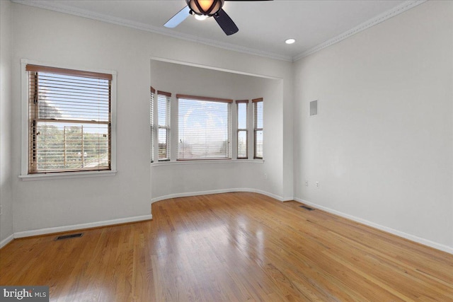 empty room with light hardwood / wood-style floors, crown molding, ceiling fan, and a wealth of natural light