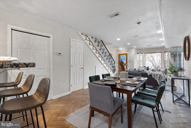 dining room with crown molding and parquet floors