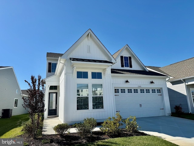 view of front facade with a front lawn, central AC, and a garage