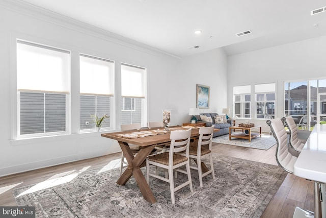 dining area with crown molding and hardwood / wood-style floors