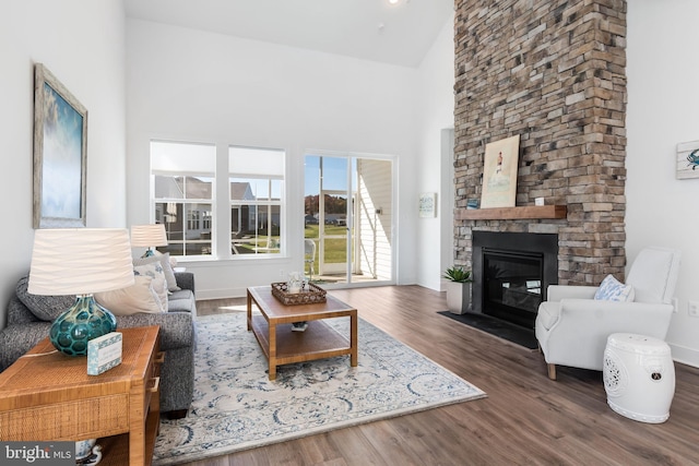 living room featuring dark hardwood / wood-style floors, high vaulted ceiling, and a fireplace