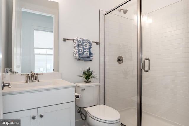 bathroom featuring vanity, toilet, and an enclosed shower