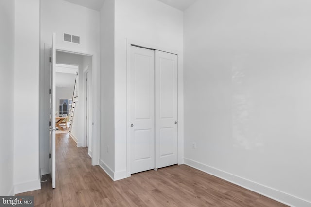 unfurnished bedroom featuring a closet and light wood-type flooring