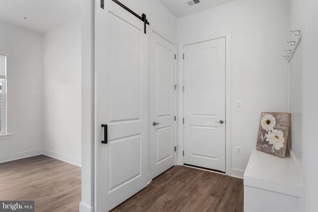 corridor featuring dark hardwood / wood-style floors and a barn door