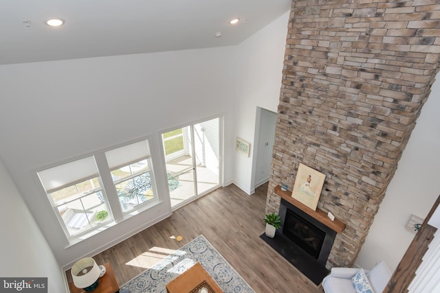 living room with high vaulted ceiling, plenty of natural light, and light wood-type flooring