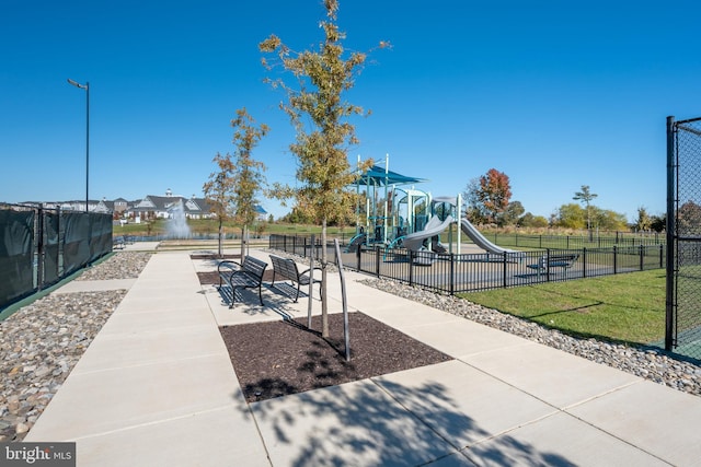 view of property's community featuring a lawn and a playground