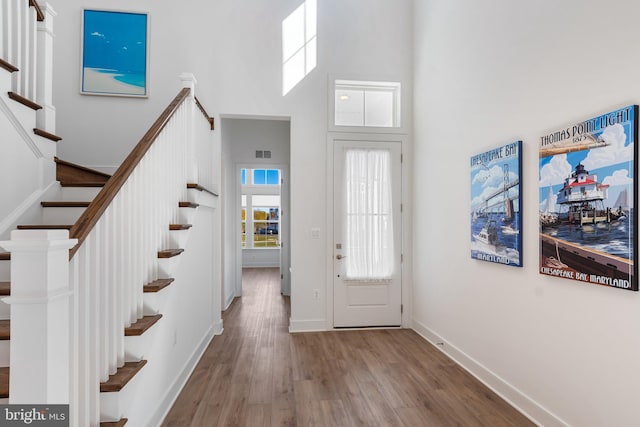 foyer entrance featuring hardwood / wood-style flooring and a towering ceiling