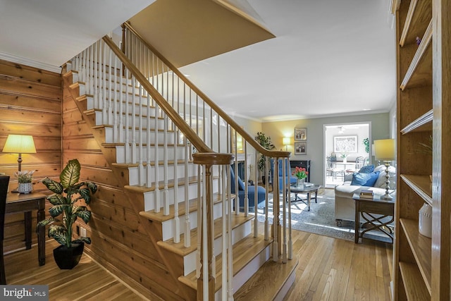 stairway featuring crown molding and hardwood / wood-style flooring