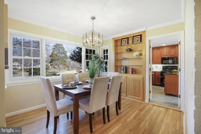 dining area with light wood-style floors, crown molding, a notable chandelier, and baseboards