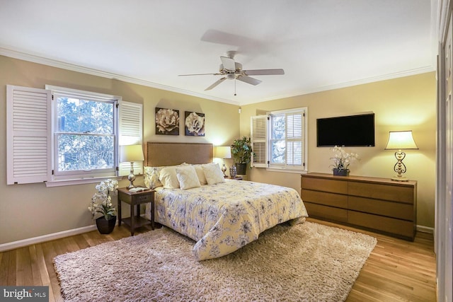 bedroom with a ceiling fan, crown molding, baseboards, and wood finished floors