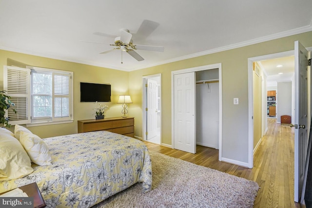 bedroom with ornamental molding, a closet, baseboards, and wood finished floors