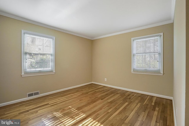 empty room with baseboards, visible vents, and light wood-style floors