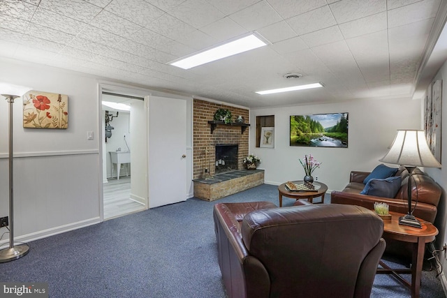 carpeted living room featuring a brick fireplace and visible vents