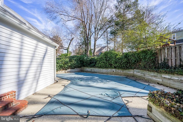 view of pool with a patio and fence