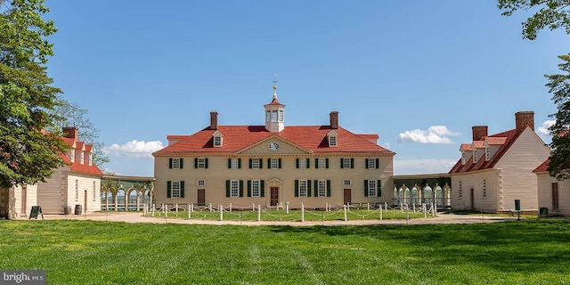 rear view of property featuring a lawn, a patio area, and fence