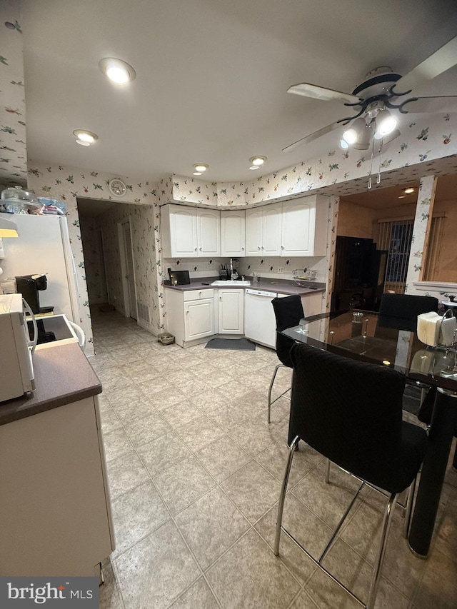 kitchen featuring ceiling fan and white cabinets