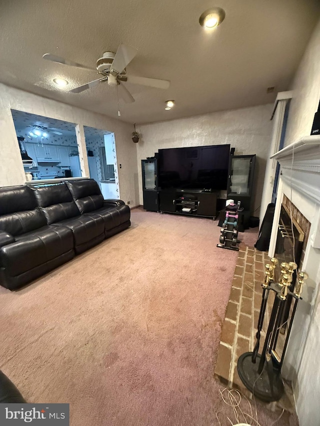 carpeted living room featuring a stone fireplace, ceiling fan, and a textured ceiling