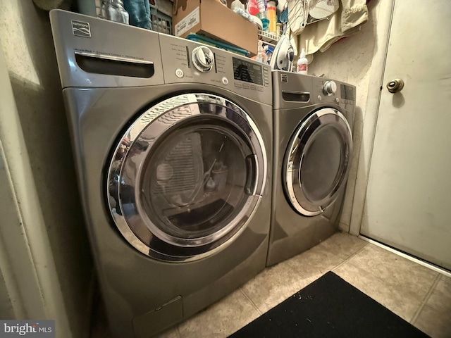 washroom with independent washer and dryer and light tile patterned floors