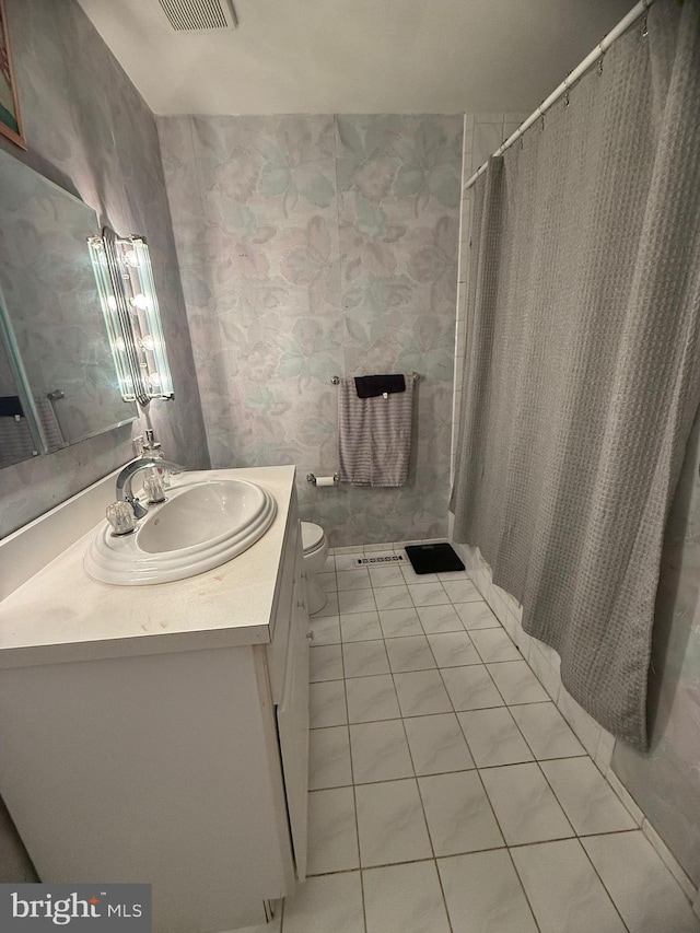 bathroom with tile patterned flooring, vanity, and toilet