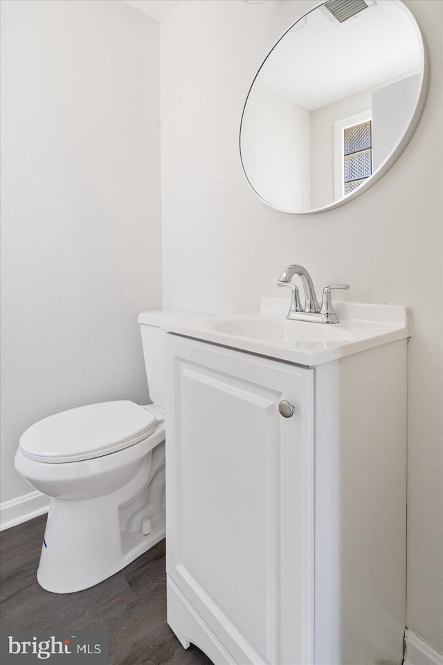 bathroom with vanity, toilet, and hardwood / wood-style floors