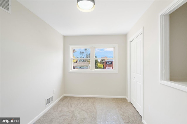 unfurnished room with light colored carpet