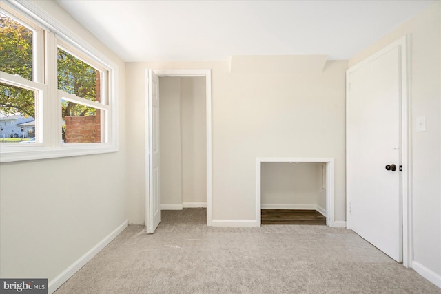 unfurnished bedroom with a closet and light colored carpet