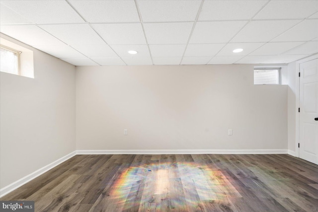 basement featuring a drop ceiling and dark hardwood / wood-style floors