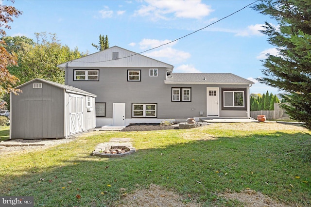 rear view of house with a yard, a storage shed, a patio area, and an outdoor fire pit