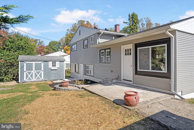 back of property with a patio, a storage unit, and a yard