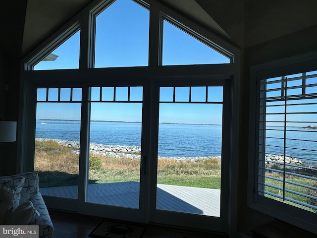 entryway featuring a water view, a healthy amount of sunlight, and a beach view