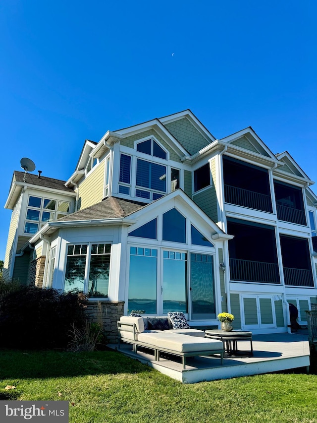 rear view of property featuring a lawn