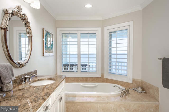 bathroom featuring tiled bath, crown molding, and vanity