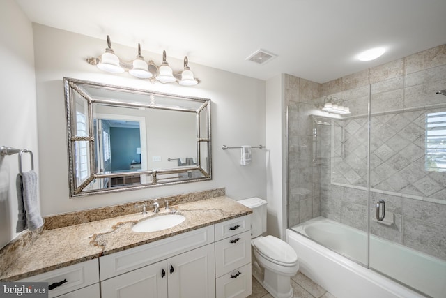 full bathroom featuring tile patterned flooring, vanity, bath / shower combo with glass door, and toilet