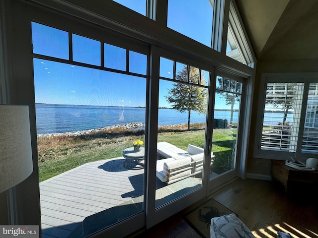 doorway to outside featuring a water view, wood-type flooring, and vaulted ceiling