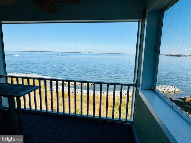 balcony featuring a water view and ceiling fan