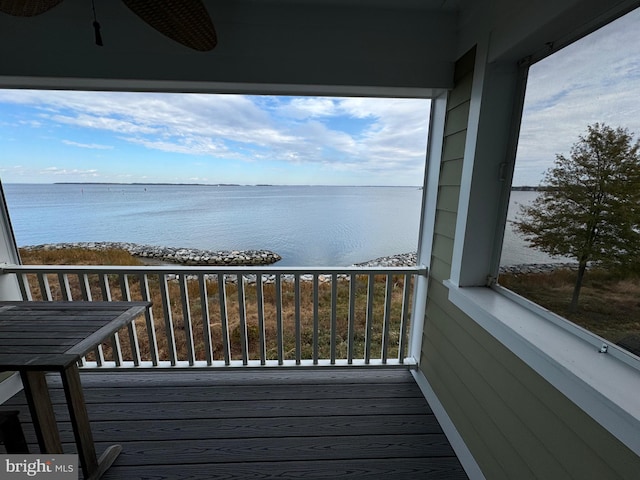 balcony with ceiling fan and a water view