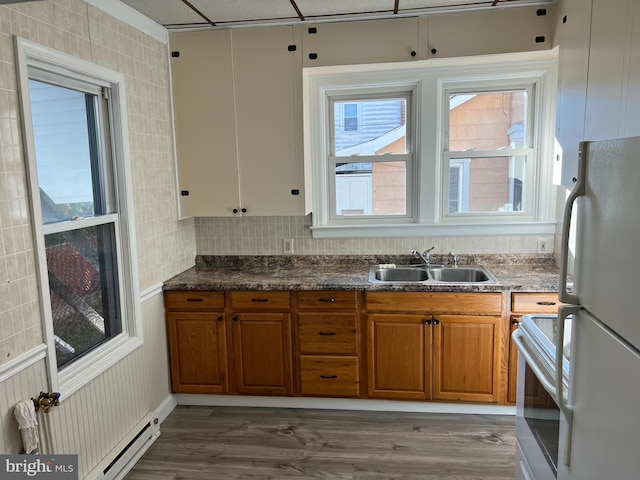 kitchen featuring white refrigerator, sink, a baseboard radiator, dark wood-type flooring, and electric range